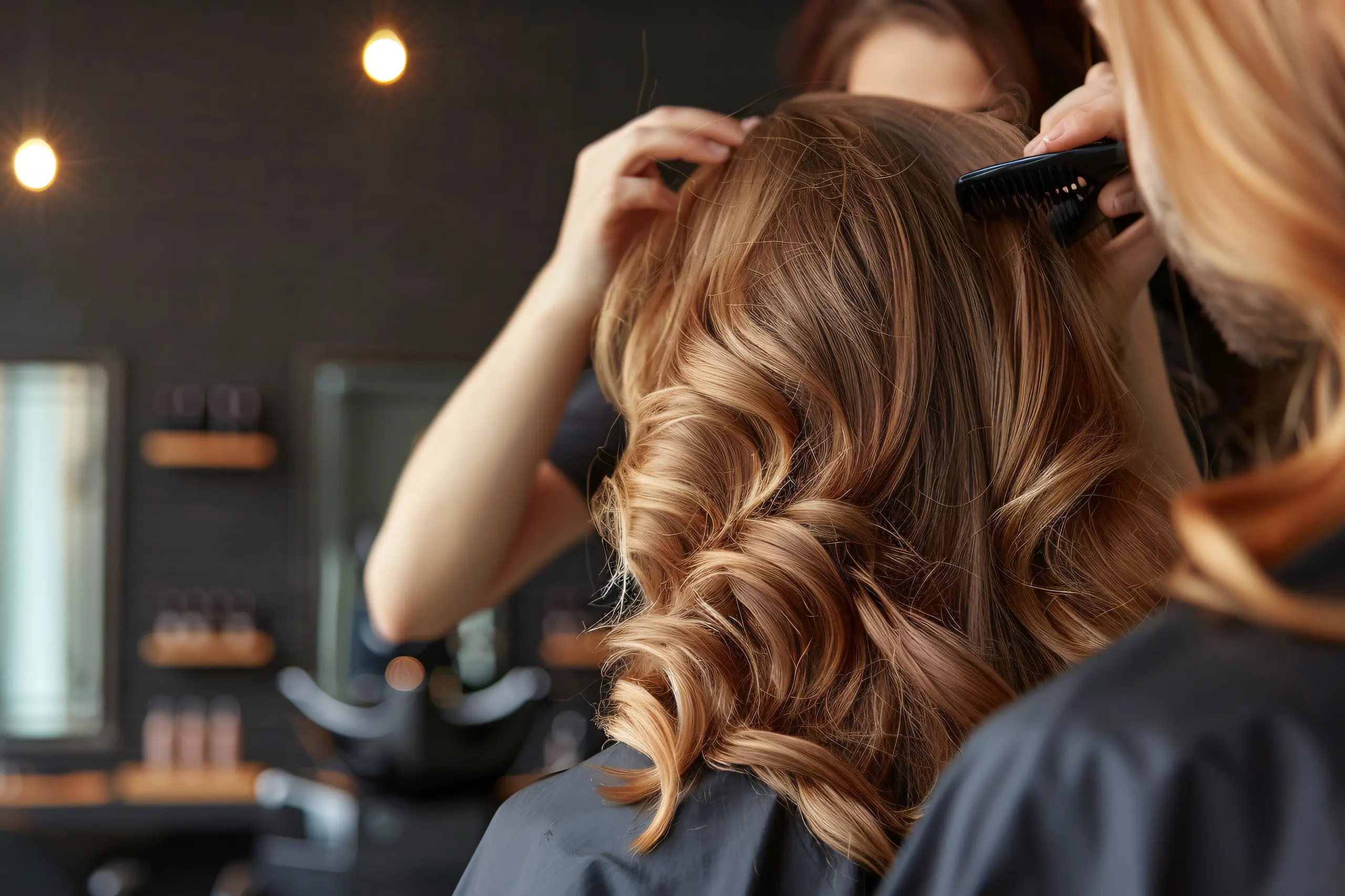 Friseurin stylt Damenfrisur mit Locken im Friseursalon in Stadtroda